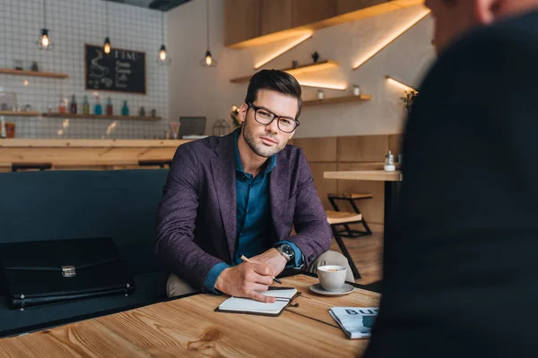Бизнесмены, имеющие встречу в кафе — стоковое фото