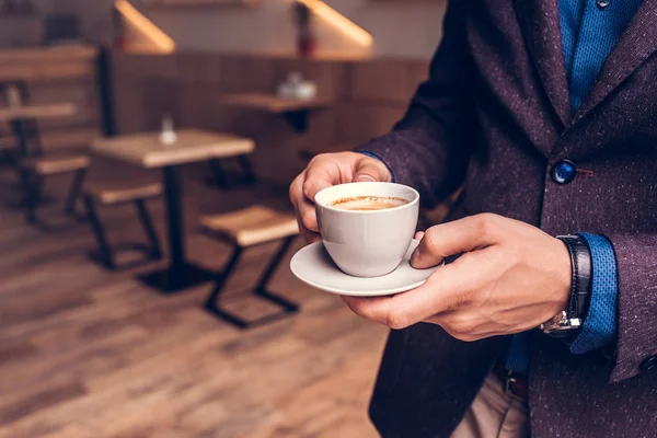 Empresário segurando xícara de café no café — Fotografia de Stock