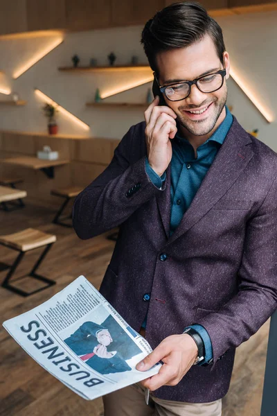 Om de afaceri cu ziare vorbind pe smartphone — Fotografie, imagine de stoc