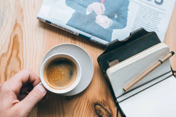 Homem de negócios com xícara de café e caderno na mesa — Fotografia de Stock