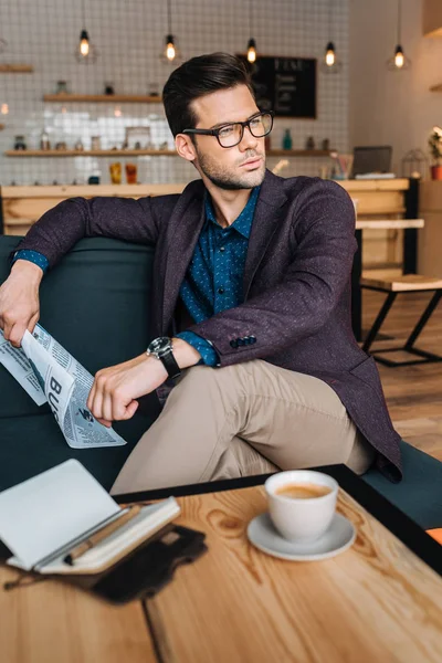 Affärsman med affärstidning i café — Stockfoto