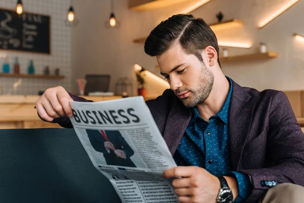 Empresario leyendo periódico en cafetería — Foto de Stock