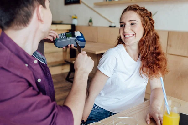 Couple paying by credit card in cafe — Stock Photo, Image