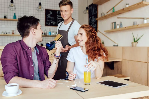 Couple paying by credit card in cafe — Stock Photo, Image