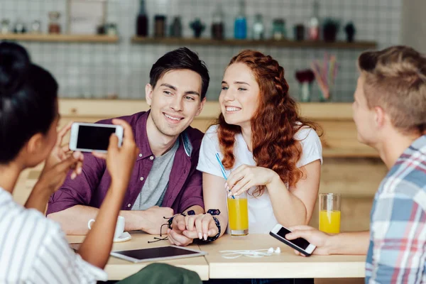 Pareja joven con amigos en la cafetería — Foto de Stock