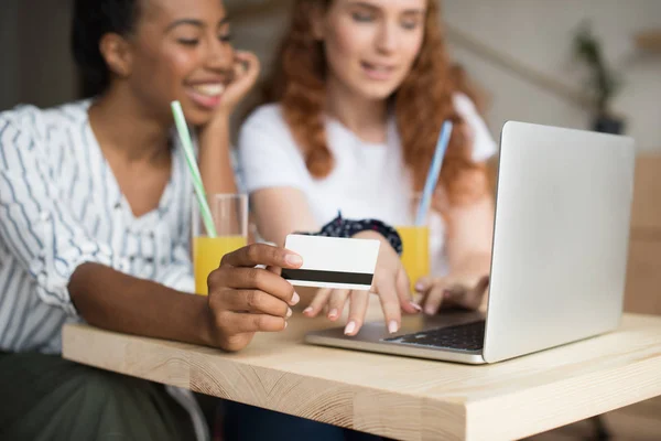 Meninas multiétnicas com laptop e cartão de crédito — Fotografia de Stock