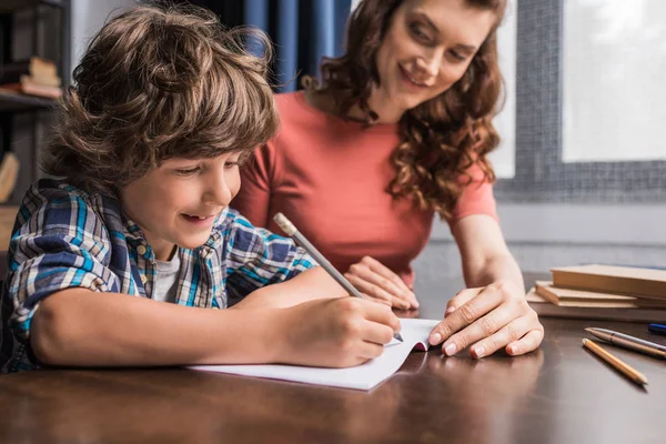 Madre ayudando a hijo con la tarea — Foto de Stock