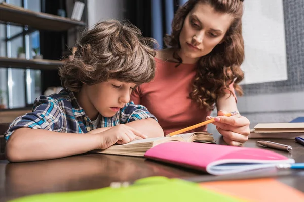 Mère aider son fils avec les devoirs — Photo