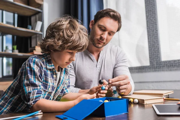 Padre e hijo jugando con el modelo de átomos — Foto de Stock