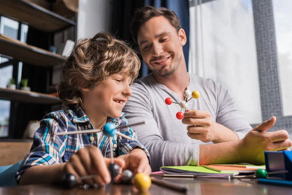 Vader en zoon spelen met atomen model — Stockfoto