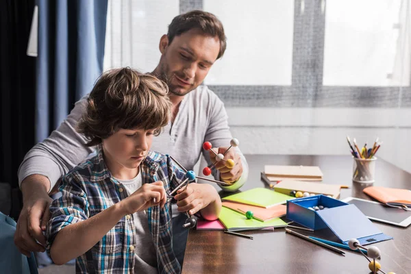 Pai e filho brincando com o modelo de átomos — Fotografia de Stock