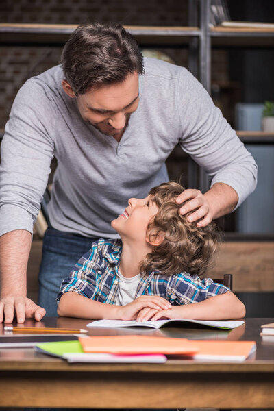 son doing homework with father