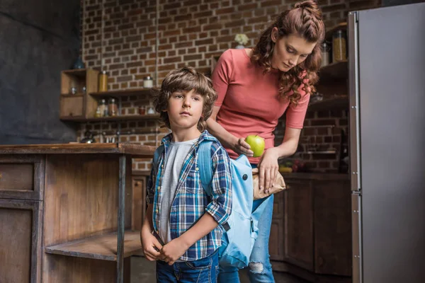 Mother packing son before school — Stock Photo, Image