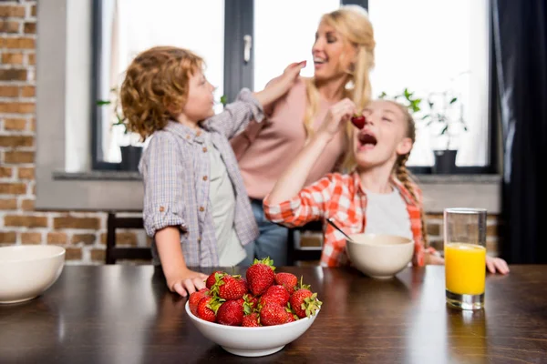 Mutter mit Kindern isst Erdbeeren — Stockfoto