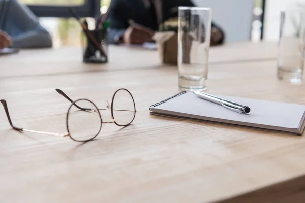 Óculos e caderno na mesa — Fotografia de Stock