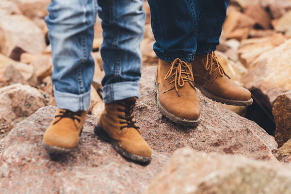 father and son standing on rocks