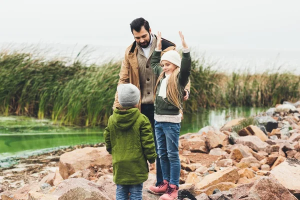 Father and kids on rocky coast — Stock Photo, Image