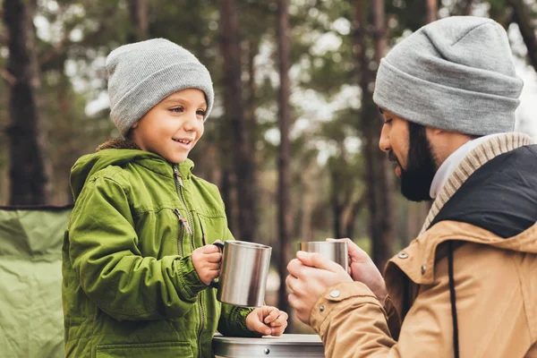 Far och son med koppar te utomhus — Stockfoto
