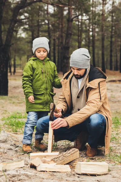 Father and son cutting wood for bonfire — Stock Photo, Image