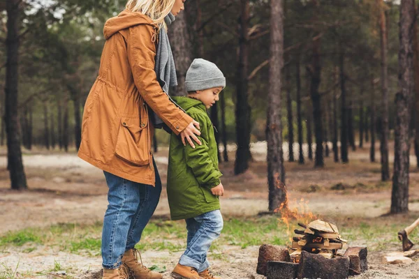 Mother and son looking at campfire — Stock Photo, Image
