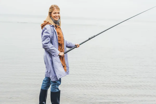 Woman fishing on cloudy day — Stock Photo, Image