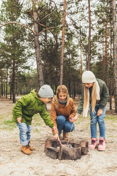Mother and kids making bonfire — Stock Photo, Image