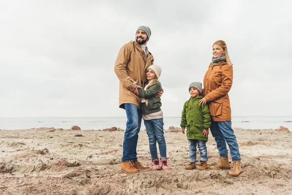 Family embracing on sandy beach — Stock Photo, Image