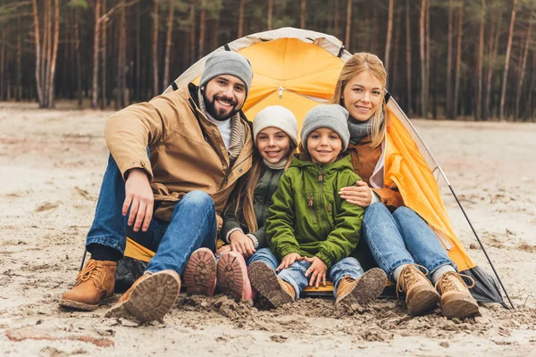 Kamp çadır yanında oturan aile — Stok fotoğraf