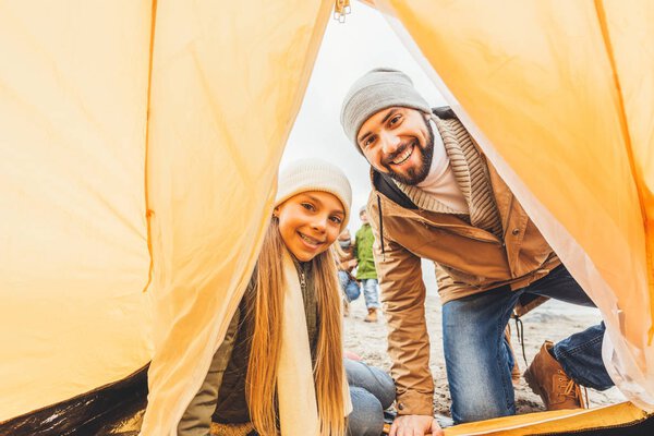 father and daughter looking at tent