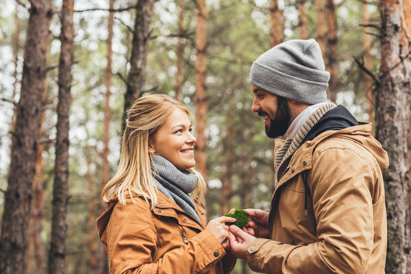 couple touching moss at forest