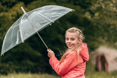 child with umbrella in autumn park clipart