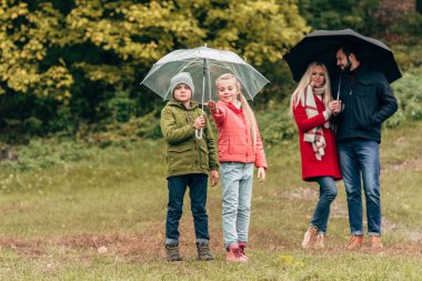 parents and kids with umbrellas clipart