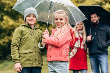 parents and kids with umbrellas clipart