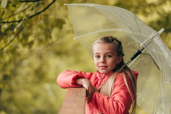 Дитина з парасолькою в осінньому парку — стокове фото