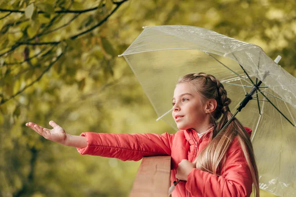 Child with umbrella in autumn park — Stock Photo, Image