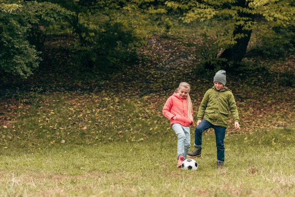 Kids playing soccer in park — Stock Photo, Image