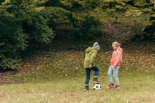 Barn som spiller fotball i parken – stockfoto