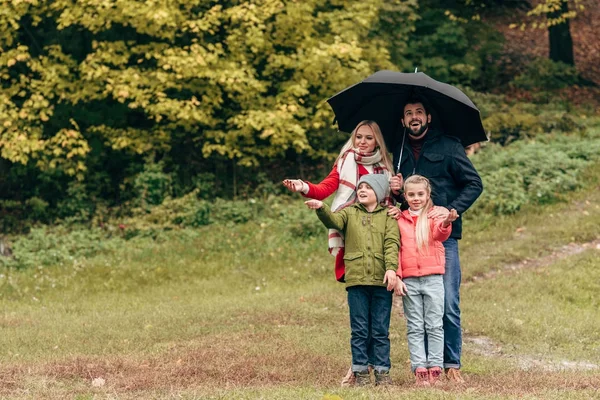 Familia con sombrilla en el parque —  Fotos de Stock