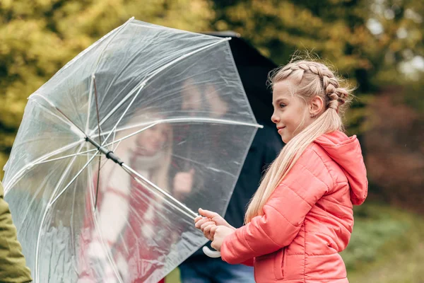 Parents and daughter with umbrellas — Stock Photo, Image