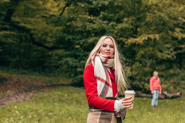 Женщина с бумажной чашкой в парке — стоковое фото