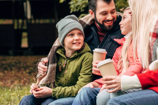 Familj med pappersmuggar i park — Stockfoto