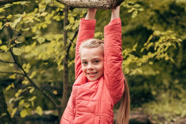 Ребенок висит на ветке дерева — стоковое фото