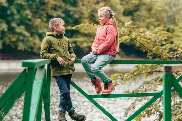 Niños cerca del lago en el parque de otoño — Foto de Stock