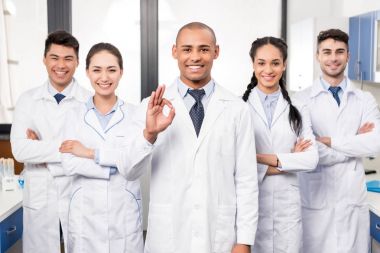 Doctor with team showing ok sign clipart