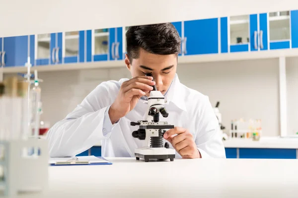 Technician using microscope — Stock Photo, Image