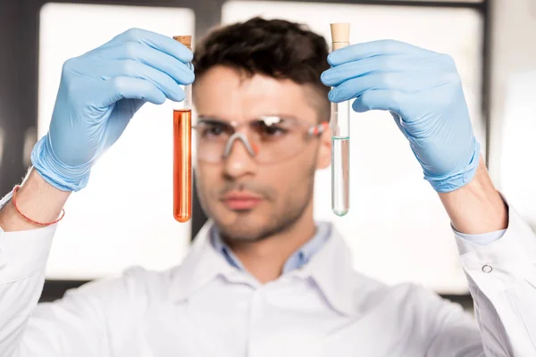 Cientista examinando tubos de ensaio — Fotografia de Stock