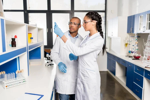 Científicos analizando tubos de ensayo en laboratorio — Foto de Stock