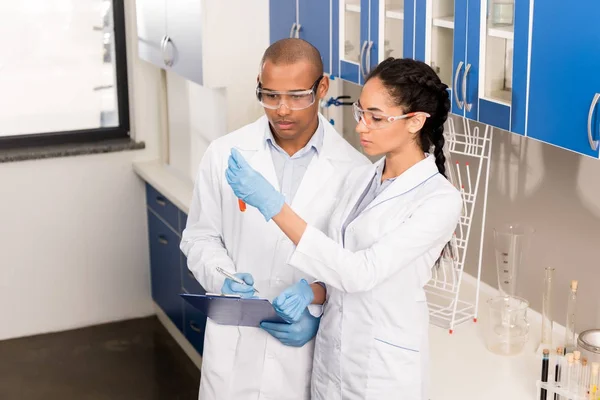 Cientistas analisando tubos de ensaio — Fotografia de Stock