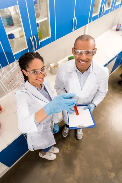 Cientistas que trabalham com amostra em tubo de ensaio — Fotografia de Stock
