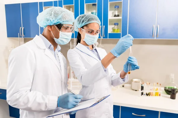 Scientists  working with test tubes — Stock Photo, Image